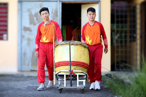 Lion dance troupe members pushing a drum cart gearing ready for Chinese New Year performance in Kuala Lumpur, Malaysia.