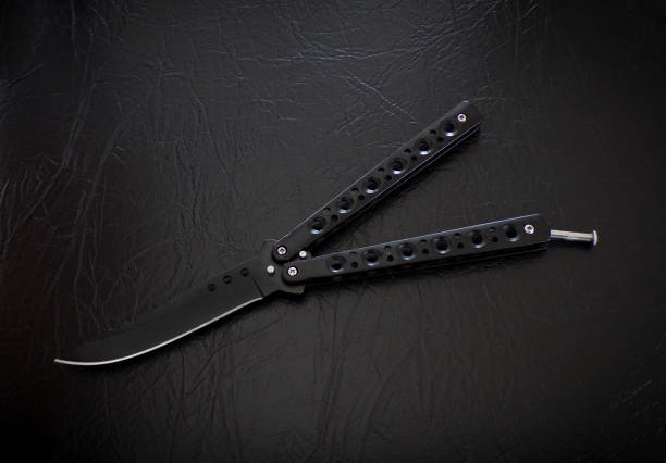 Butterfly knife on a black leather background.