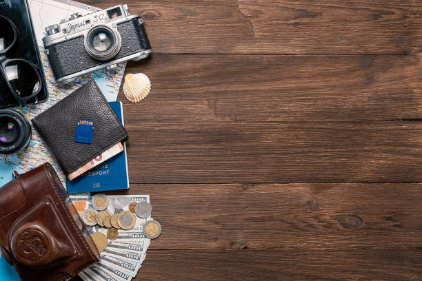 istock various things for travel on a wooden background. Soviet retro camera and wallet with money, sunglasses and smartphone with a passport 1197805521