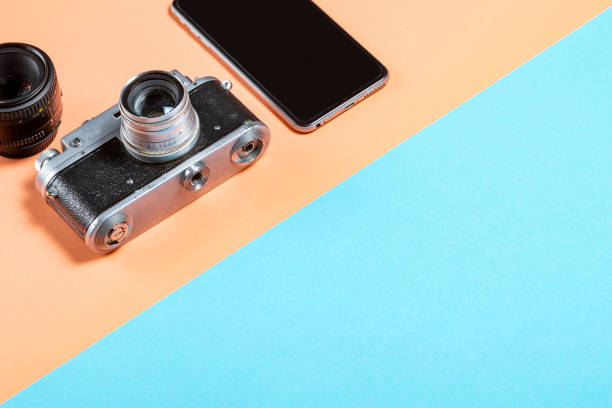 istock old Soviet camera with a smartphone and lens on a pink-blue background 1197805530