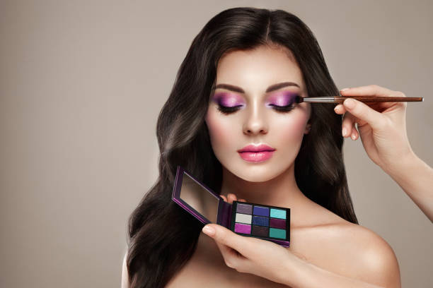 Makeup artist applies eye shadow Makeup artist applies eye shadow. Beautiful woman face. Perfect makeup. Make-up detail. Beauty girl with perfect skin. Nails and manicure. Eye shadow palette stage make up stock pictures, royalty-free photos & images