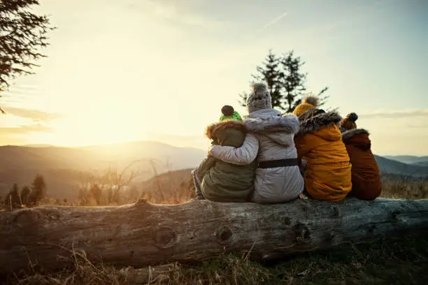 Photo of Mother and kids enjoying sunset in mountains