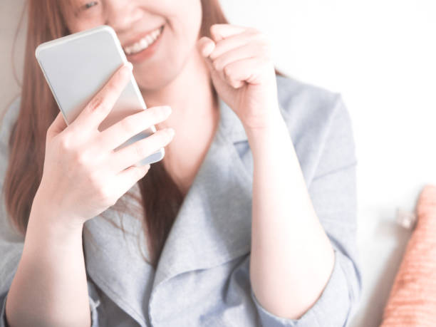 istock Midsection Of Woman Using Mobile Phone While Sitting At Home 1197812052