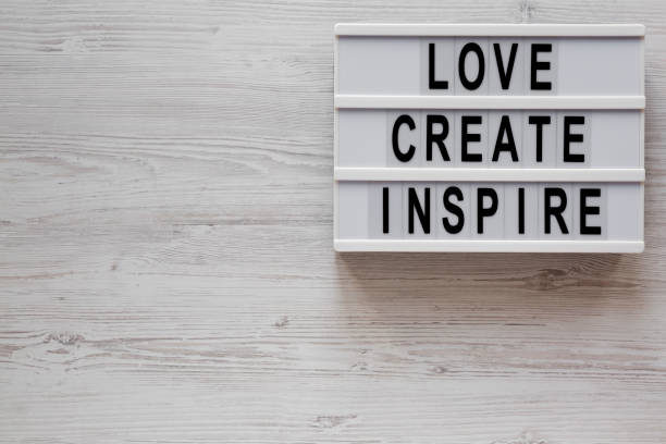 istock 'Love create inspire' words on a modern board on a white wooden background, top view. Overhead, from above, flat lay. Space for text. 1197812928