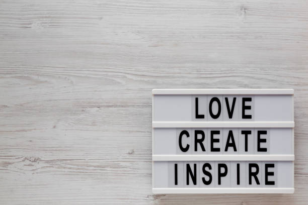 istock 'Love create inspire' words on a lightbox on a white wooden background, top view. Overhead, from above, flat lay. Space for text. 1197813041