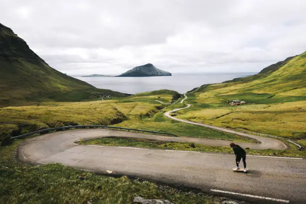 Photo of Young skater riding a skateboard through the beatiful scenery of Faroe Islands