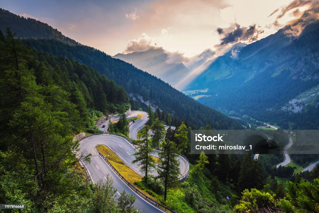 Maloja Pass road in Switzerland at sunset Aerial view of Maloja Pass road in Switzerland at sunset. This Swiss Alps mountain road is located in dense forests of the canton Graubunden. Switzerland Stock Photo