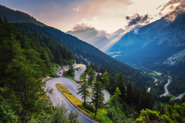 Maloja Pass road in Switzerland at sunset Aerial view of Maloja Pass road in Switzerland at sunset. This Swiss Alps mountain road is located in dense forests of the canton Graubunden. maloja region stock pictures, royalty-free photos & images