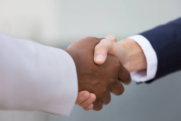Closeup of multiethnic female business handshake stock photo