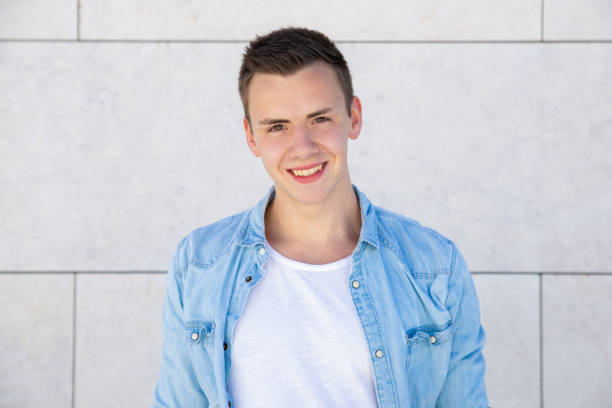 istock Happy cheerful student guy standing over pale outdoor wall 1197817209