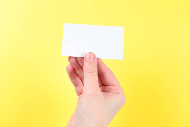istock Empty card in woman hand  on a yellow background 1197817659