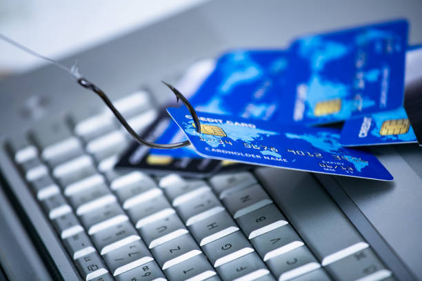 phishing de cartão de crédito. pilhas de cartões de crédito com um gancho de peixe no teclado de computador. golpe de phishing de cartão de crédito com cartão de crédito no gancho de pesca - internet e mail paying credit card - fotografias e filmes do acervo