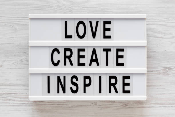 istock 'Love create inspire' words on a lightbox on a white wooden background, top view. Overhead, from above, flat lay. 1197821670