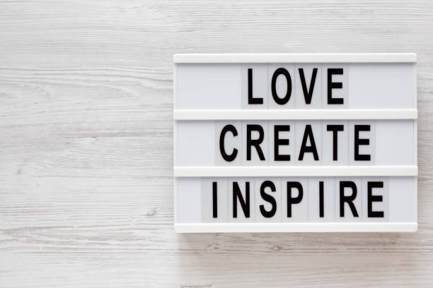 istock 'Love create inspire' words on a modern board on a white wooden surface, top view. Overhead, from above, flat lay. Copy space. 1197821724