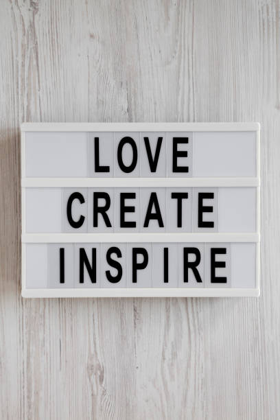 istock 'Love create inspire' words on a lightbox on a white wooden background, top view. Overhead, from above, flat lay. 1197822052