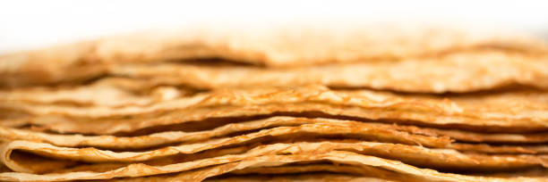 Close up on a stack of crepes (french pancakes) on a plate, white panoramic background, web banner Close up on a stack of crepes (french pancakes) on a plate, white panoramic background, web banner candlemas stock pictures, royalty-free photos & images