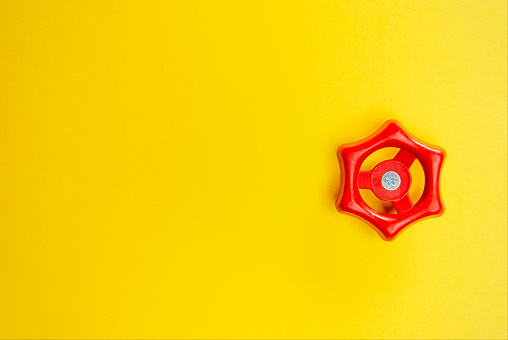 Red valve on yellow paper background.
