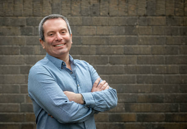 istock Middle aged man against a brick wall, looks at camera 1197825586