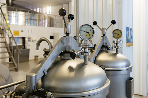 Manometer on the cylinder with gas in and hop dispenser in modern brewery. Close-up view.