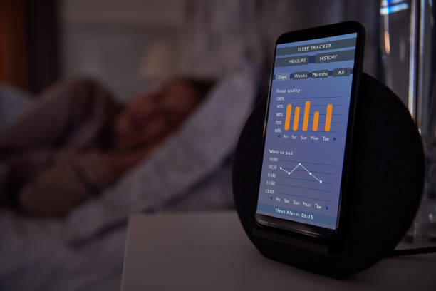 Woman Sleeping In Bed With Sleep Data App Running On Mobile Phone On Bedside Woman Sleeping In Bed With Sleep Data App Running On Mobile Phone On Bedside tracker stock pictures, royalty-free photos & images