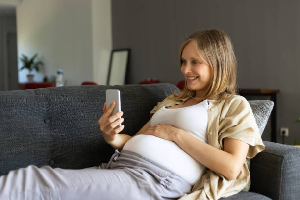 istock Cheerful excited expectant mother using cellphone for selfie 1197830402