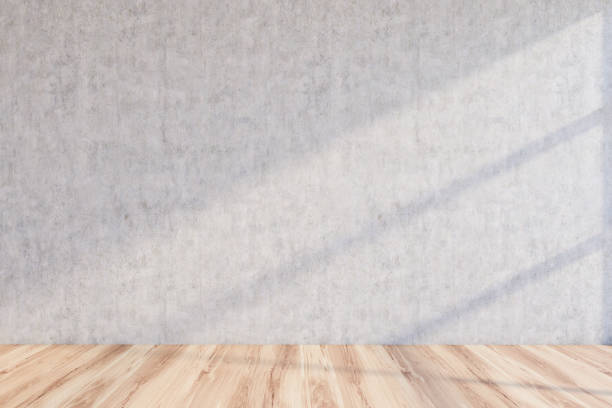 istock Empty room with light concrete wall and wood floor 1197832295