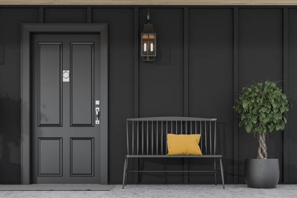 istock Black front door of black house, tree and bench 1197832942