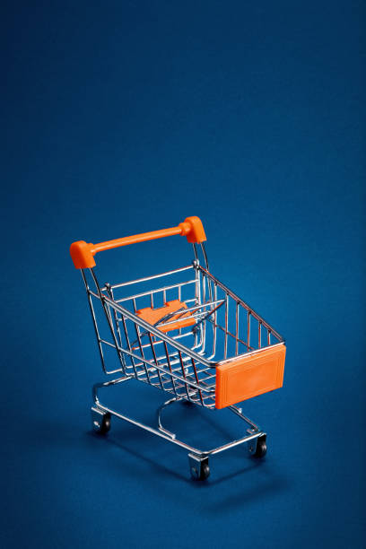 istock Empty shopping cart trolley on blue background with copy space 1197833123
