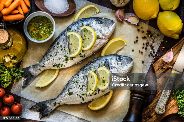 Cooking Fish Meat With Lemon Parsley And Garlic Stock Photo - Download Image Now - Fish, Barbecue Grill, Dinner