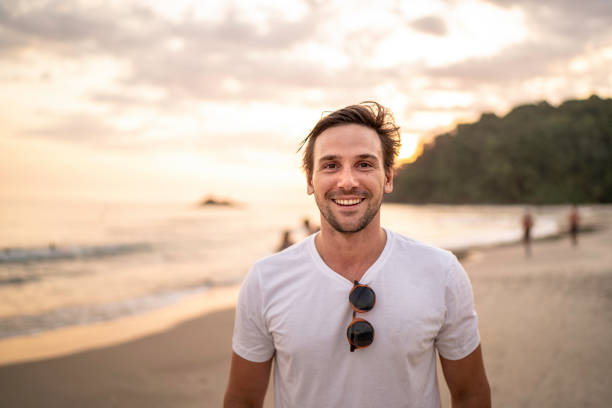 ritratto di uomini sorridenti in spiaggia - vacations tourism travel white sand foto e immagini stock