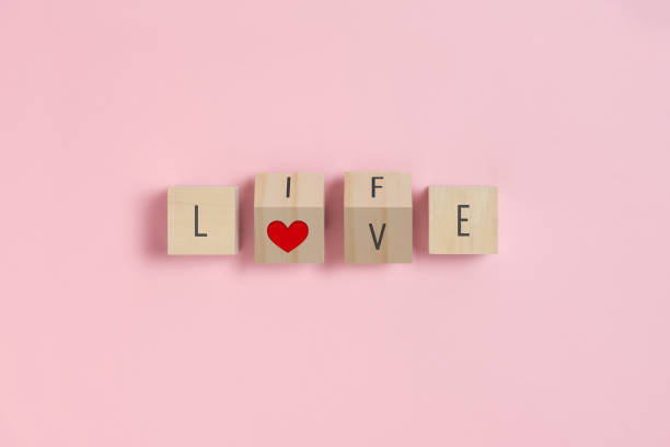 amor, texto life y corazón rojo sobre cubos de madera sobre fondo rosa. - beautiful red pink wood fotografías e imágenes de stock