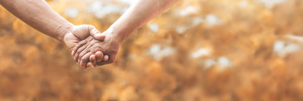 istock Senior couple holding hands together over nature background. 1197834462
