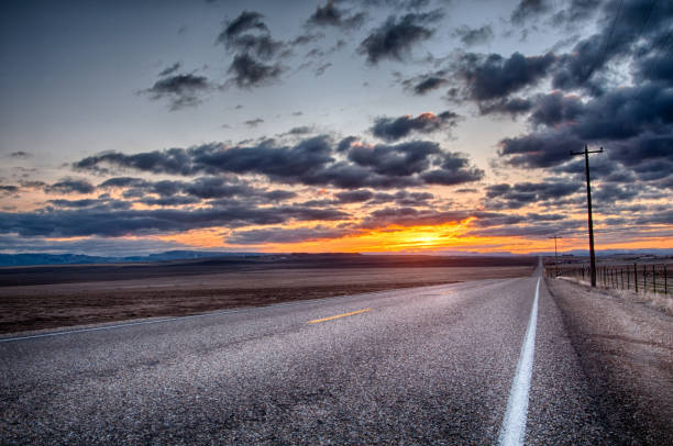 istock Asphalt road leading off into the cloudy horizon 1197835680