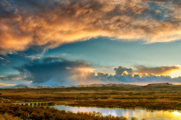 Dark and fading sun illuminated cloud covered sky in the late evening looking over the Snake River with the Owyhee Mountain Rage in the distant in Idaho