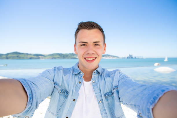istock Joyful excited tourist guy taking selfie at sea 1197838488