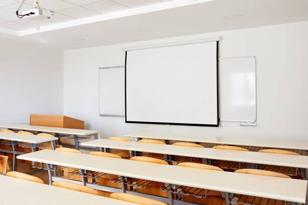 istock Classroom interior with projection screen, white board and wooden desks 1197838665