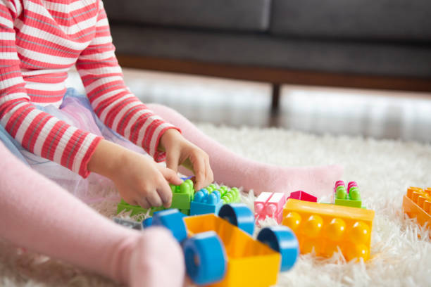 istock Little girl playing with toy blocks 1197840056