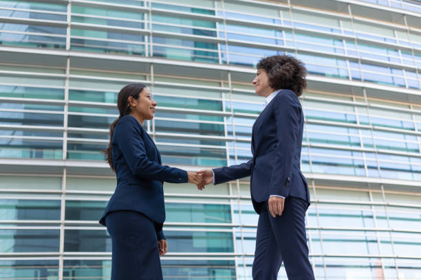 istock Friendly business partners greeting each other near office 1197841375