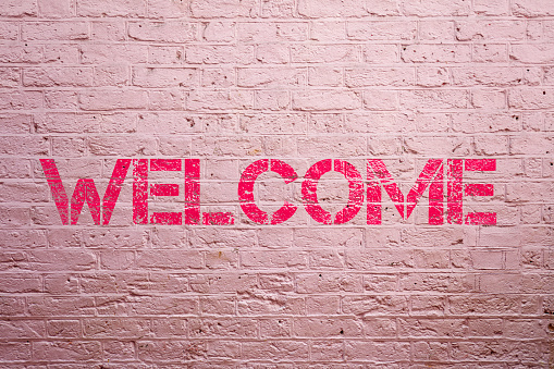 Word welcome on pink wall background