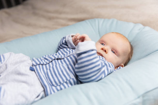 istock Curious pensive red haired baby in blue and grey clothes 1197842570