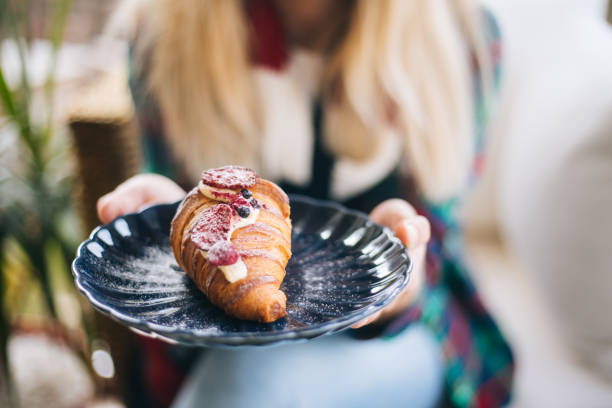 istock Woman holding croissant with berries 1197843339