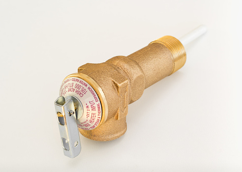 Temperature and pressure relief or TPR valve on white.
