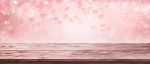 istock Flying pink hearts with wooden table 1197847859