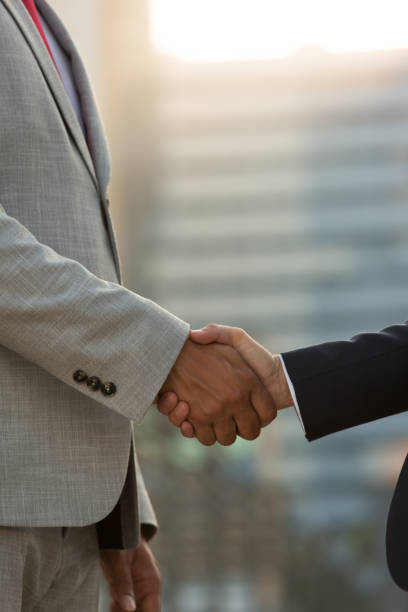 istock Professionals in formal suits greeting each other in city 1197855003