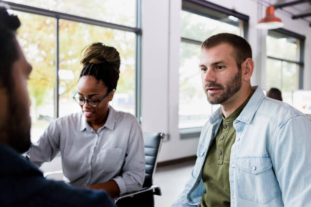 istock Two men have discussion while woman uses pen on tablet 1197855942