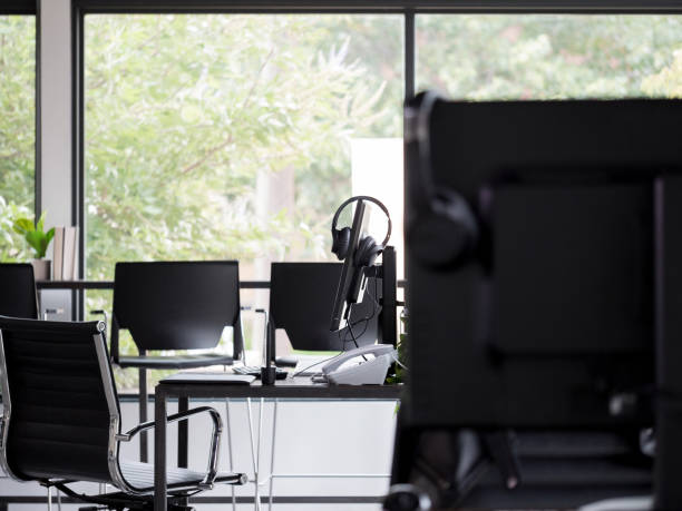 istock Coworking space desks, phones, and computer equipment ready for use 1197856179