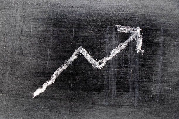 istock White chalk draw as upward arrow graph on black board background (Concept for sale, profit, cost of company in uptrend) 1197860605