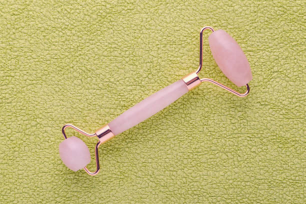 istock rose quartz facial roller green background, flat lay 1197862874