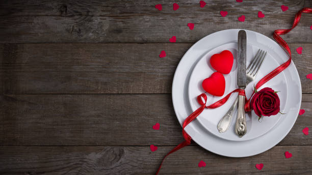 istock Valentine's day dinner concept, flat white plate, fork, knife and two red heart 1197863526