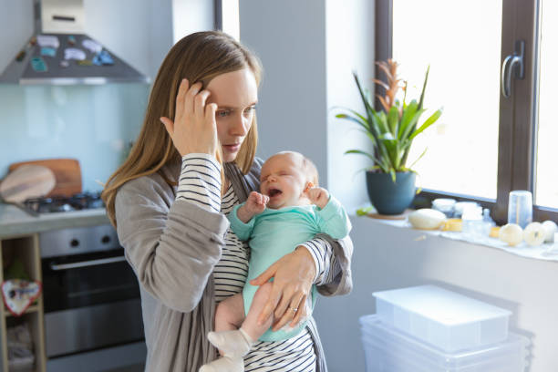 müde besorgt neue mutter schaukeln weinende baby - new mother stock-fotos und bilder